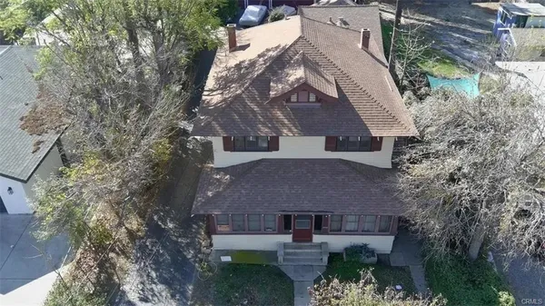 an aerial view of a house with garden space and a building