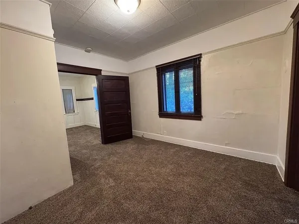 an empty room with a hallway and stairs