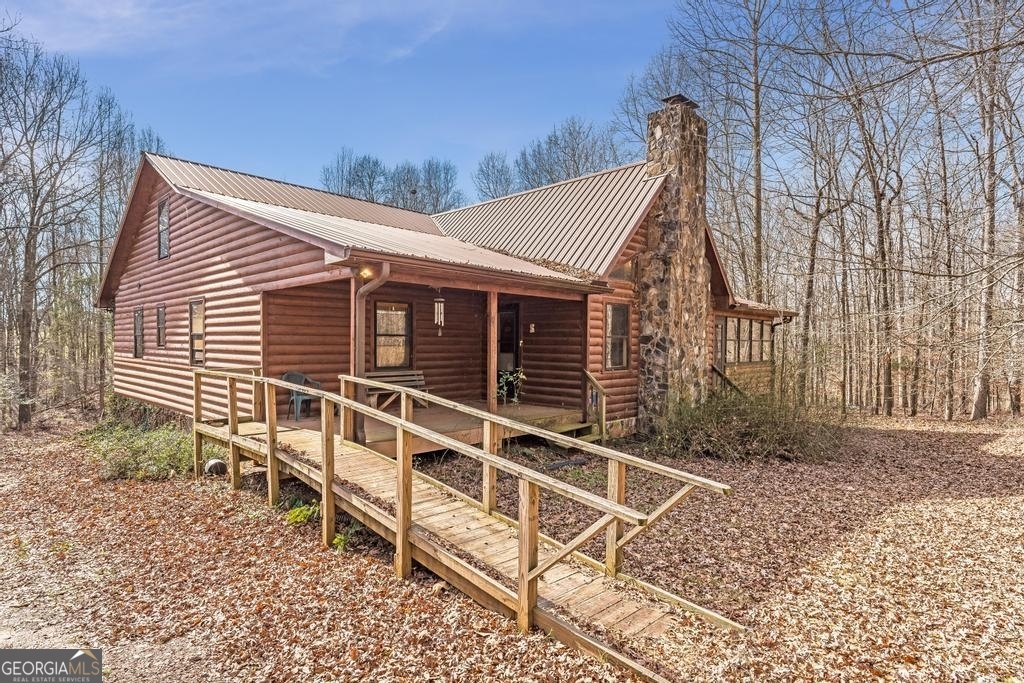 540 Beaver Creek Road Canon, GA 30624 - Photo 1 of 1 a wooden house with a large window and wooden fence