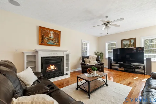a living room with furniture a flat screen tv and a fireplace