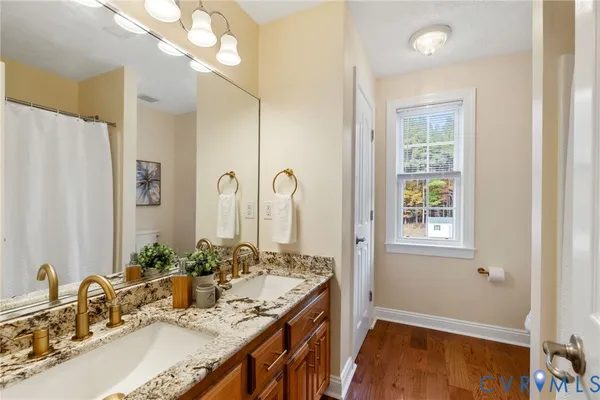 a bathroom with a granite countertop sink a large mirror and a shower