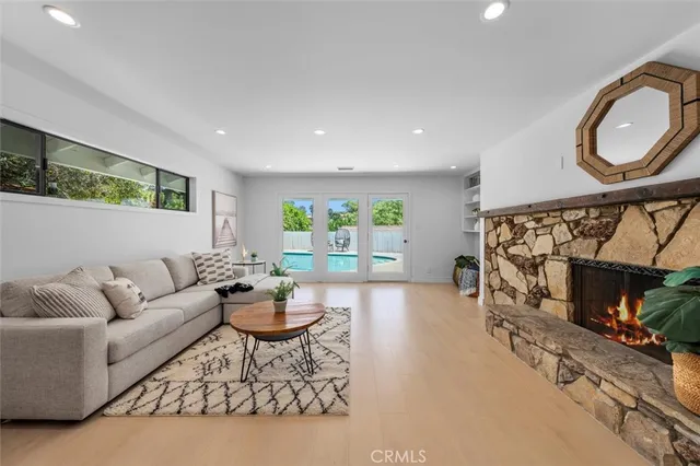 a living room with furniture a fireplace and a large window