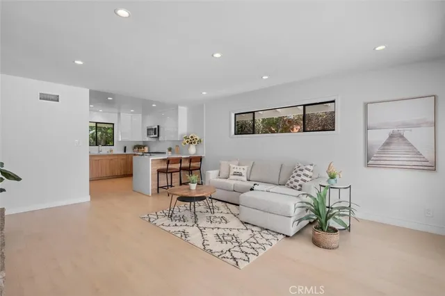 a living room with furniture and a dining table with kitchen view