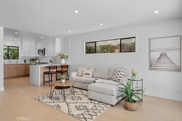 a living room with furniture a fireplace and a large window