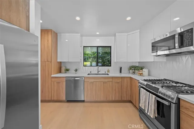 a kitchen with granite countertop a sink window and cabinets