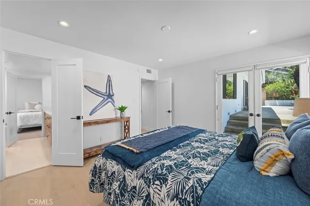 a bedroom with a large bed and windows