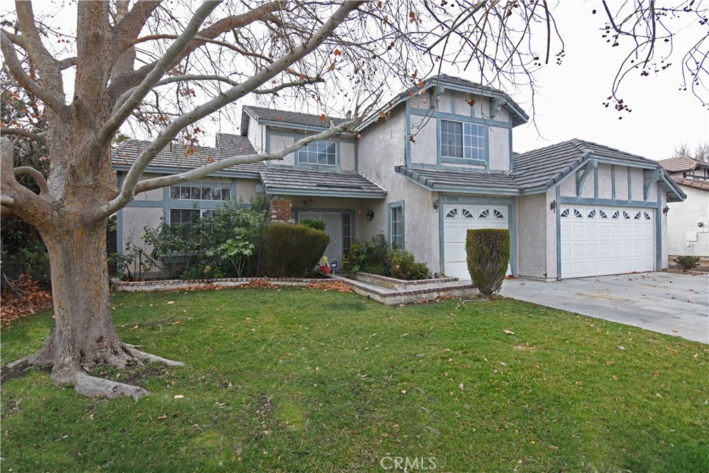 12790 Ponderosa Ranch Road Victorville, CA 92392 - Photo 1 of 1 a front view of a house with a garden and trees