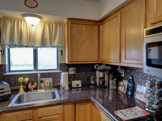 a kitchen with sink a refrigerator and cabinets