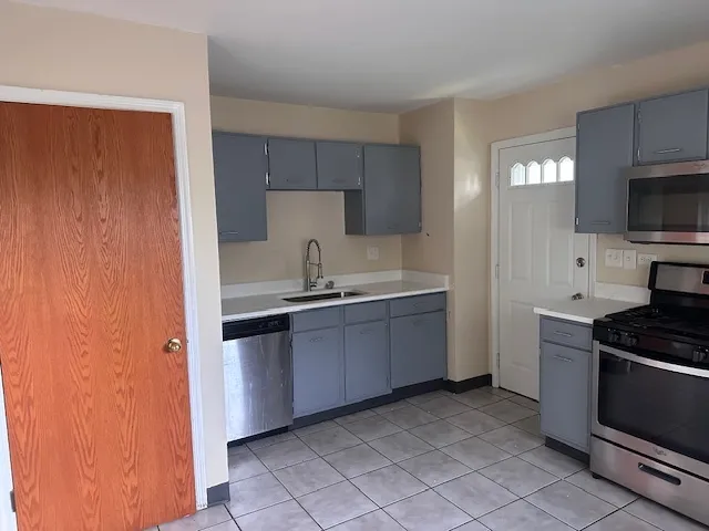 a kitchen with granite countertop a sink stainless steel appliances and cabinets