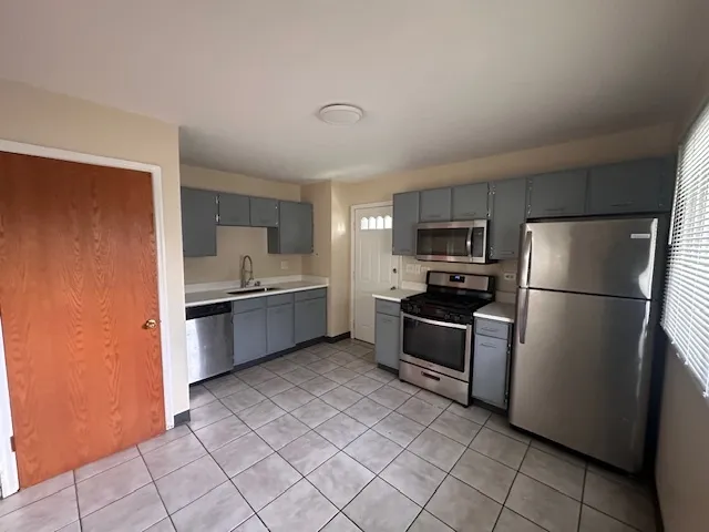 a kitchen with stainless steel appliances granite countertop a refrigerator sink and stove