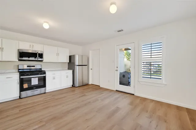 a kitchen with granite countertop a refrigerator and a stove top oven