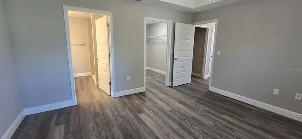an empty room with wooden floor and entrance