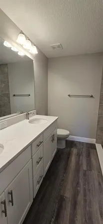 a spacious bathroom with a double vanity sink and a mirror