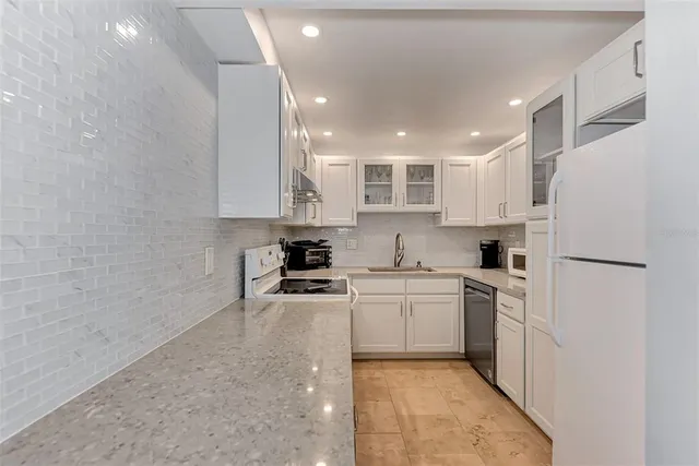 a bathroom with a granite countertop sink a mirror a bathtub and shower
