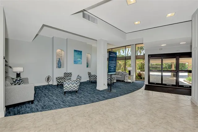 a living room with furniture a flat screen tv and a large window