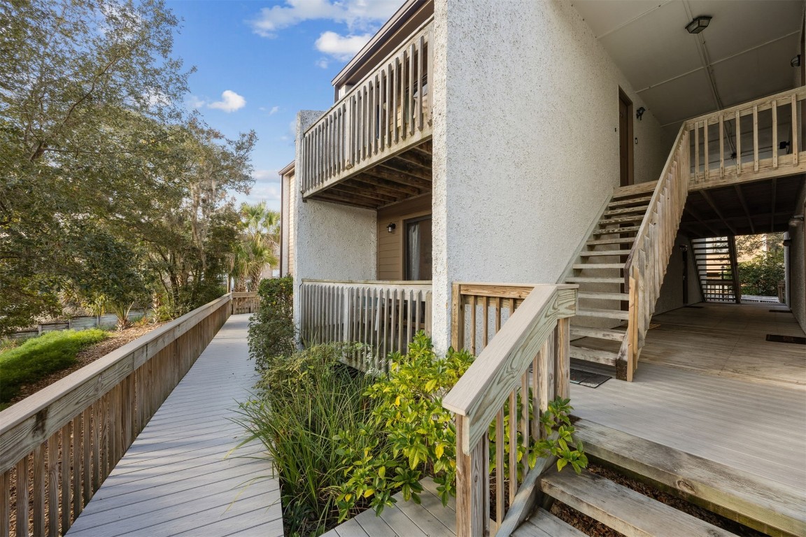 a balcony of an outdoor space with wooden floor and stairs
