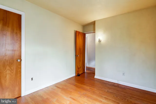 an empty room with wooden floor and closet