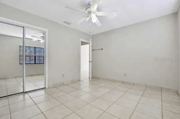 an empty room with chandelier fan