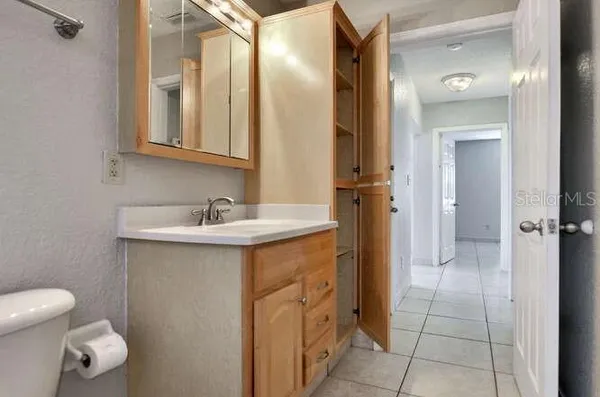a spacious bathroom with a granite countertop sink a toilet and a mirror