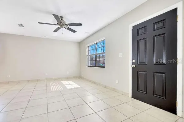a view of an empty room with cabinet and chandelier fan
