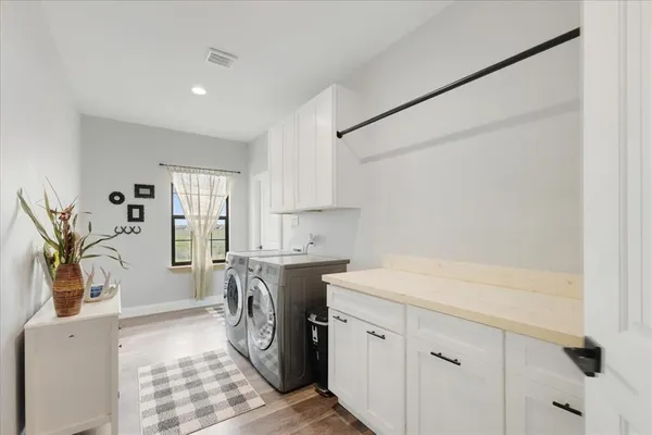 a utility room with cabinets washer and dryer