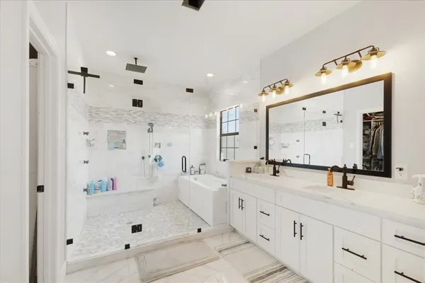 a bathroom with a double vanity sink mirror and shower
