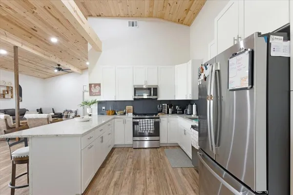 a kitchen with a refrigerator a sink and cabinets
