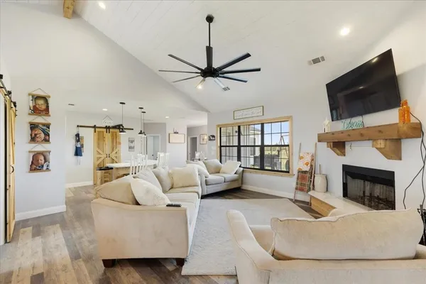a living room with furniture a fireplace and a flat screen tv