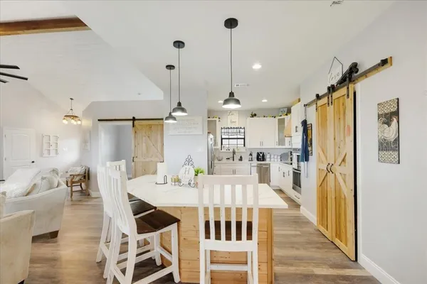 a view of a dining room and livingroom with furniture wooden floor a chandelier