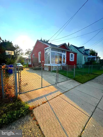 a backyard of a house with barbeque oven and a garden