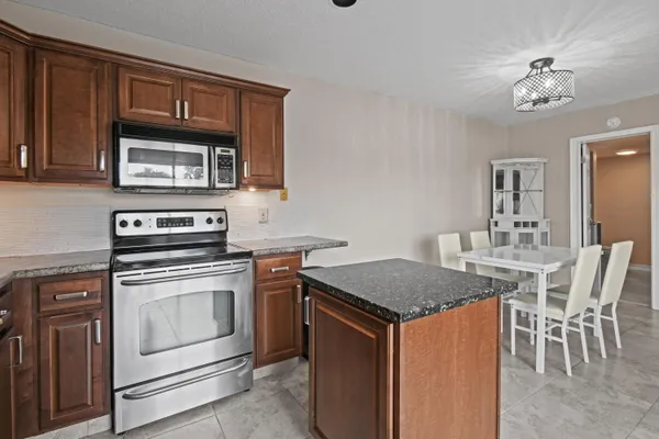 a kitchen that has a stove and a table chair