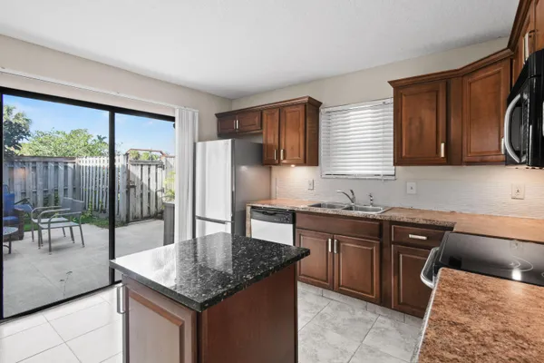 a kitchen with stainless steel appliances granite countertop a sink dishwasher stove and refrigerator