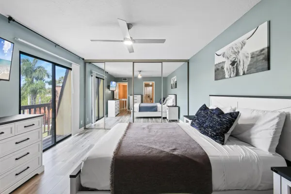a bedroom with a large bed and a flat tv screen on dresser