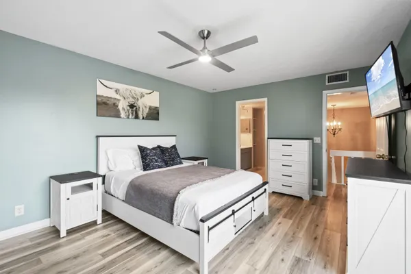 a bedroom with a bed a large window and a flat screen tv