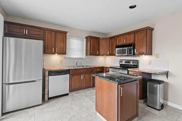 a kitchen with stainless steel appliances granite countertop a refrigerator stove microwave and sink