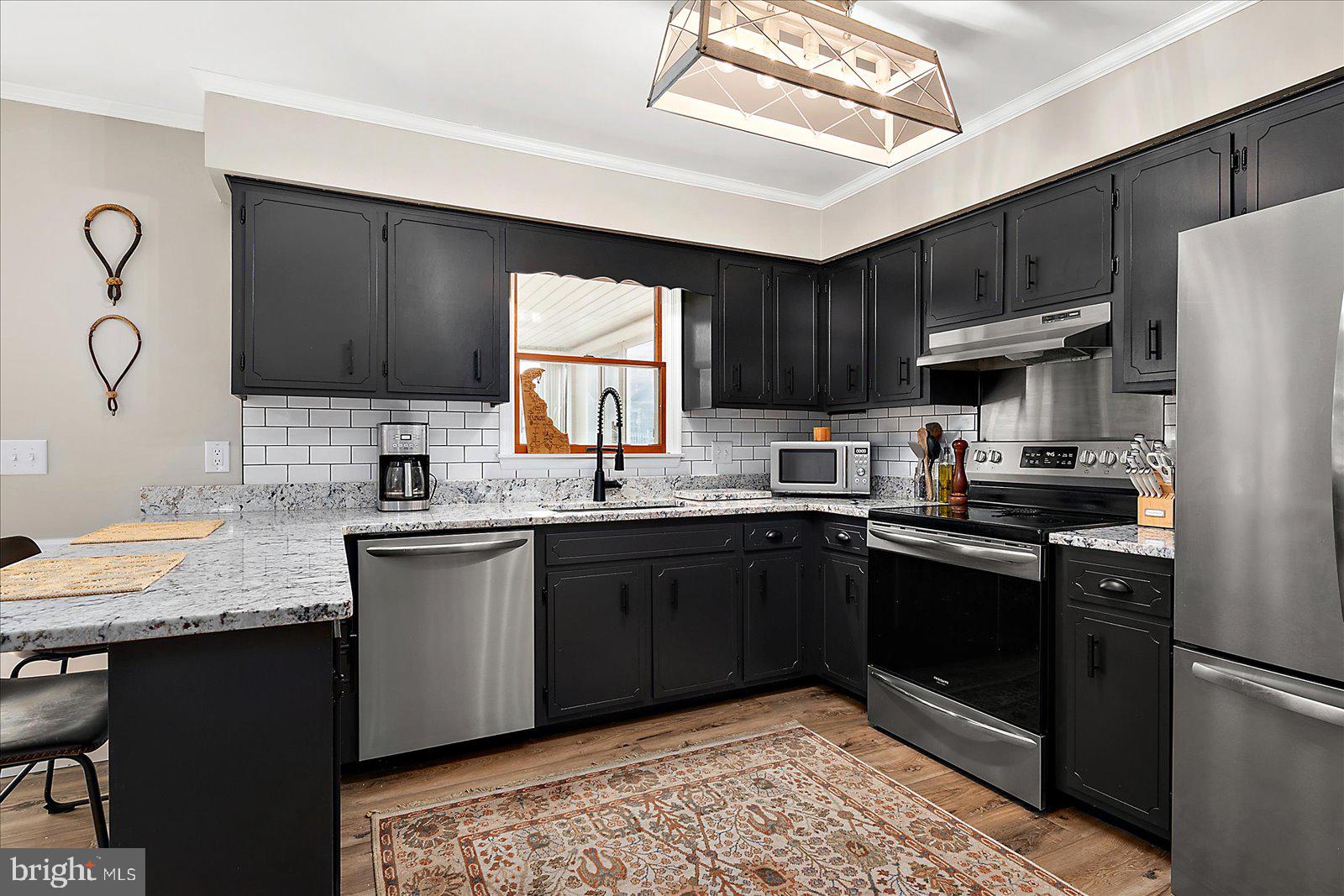 30069 Cedar Neck Road Ocean View, DE 19970 - Photo 7 of 61 a kitchen with granite countertop wooden cabinets and a sink