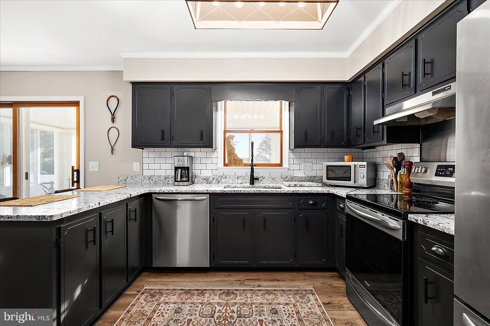 30069 Cedar Neck Road Ocean View, DE 19970 - Photo 8 of 61 a kitchen with granite countertop stainless steel appliances a sink dishwasher a stove top oven and cabinets