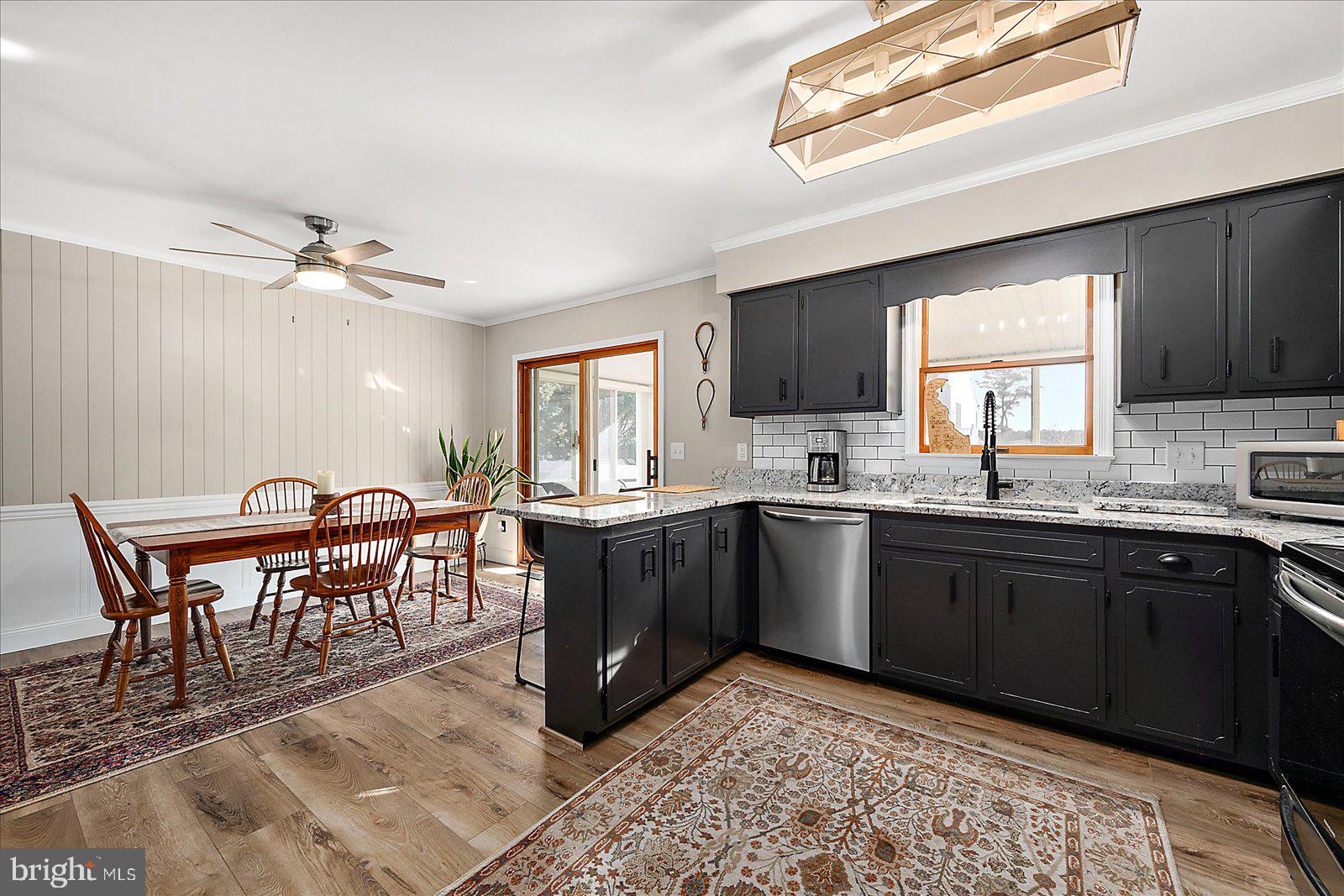 30069 Cedar Neck Road Ocean View, DE 19970 - Photo 10 of 61 a kitchen with stainless steel appliances granite countertop a stove a sink a dining table and chairs