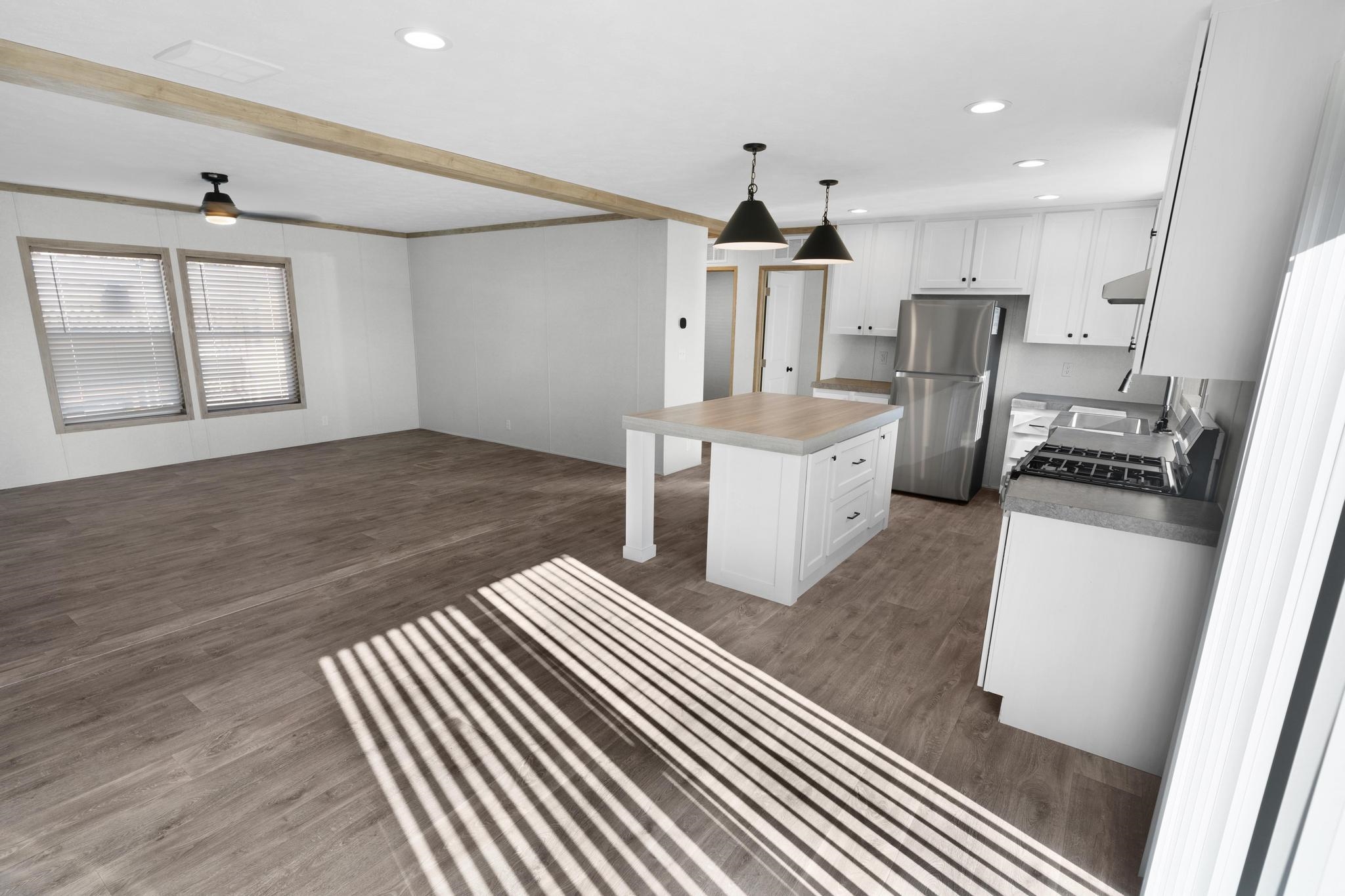 3195 F Road, Unit 8 Grand Junction, CO 81504 - Photo 5 of 26 a open kitchen with white cabinets a sink dishwasher and a stove with wooden floor