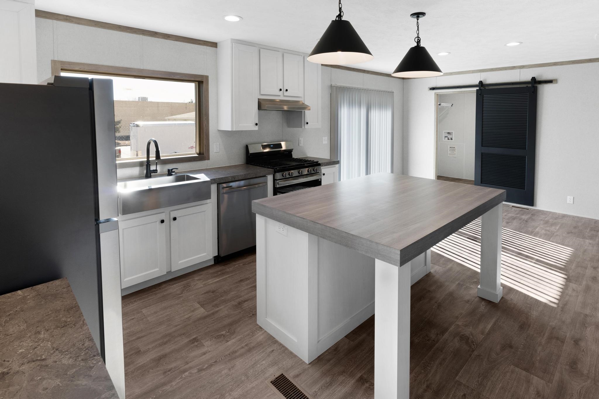 3195 F Road, Unit 8 Grand Junction, CO 81504 - Photo 7 of 26 a kitchen with stainless steel appliances granite countertop a sink a microwave a refrigerator and white cabinets