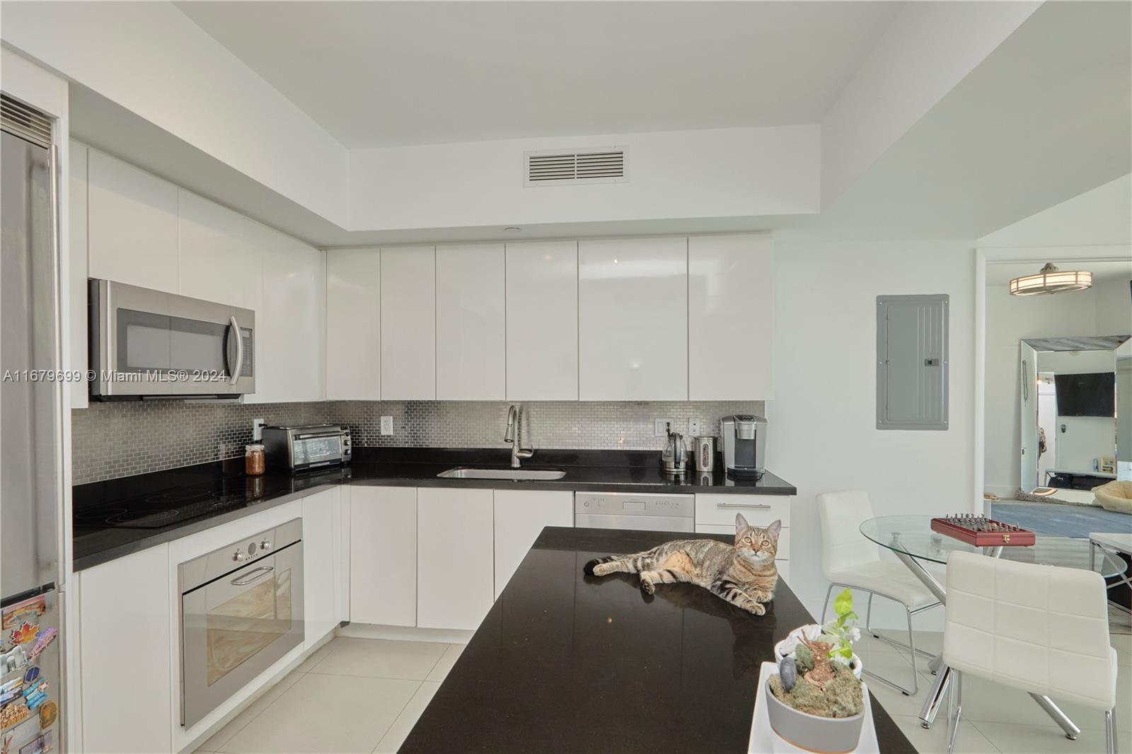 92 Southwest 3rd Street, Unit 1211 Miami, FL 33130 - Photo 5 of 17 a kitchen with stainless steel appliances granite countertop a sink a stove a microwave a sink a refrigerator and white cabinets