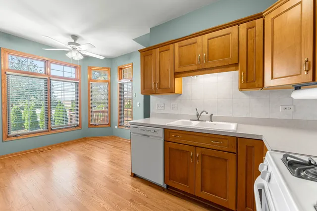 a kitchen with stainless steel appliances granite countertop a sink cabinets and wooden floor