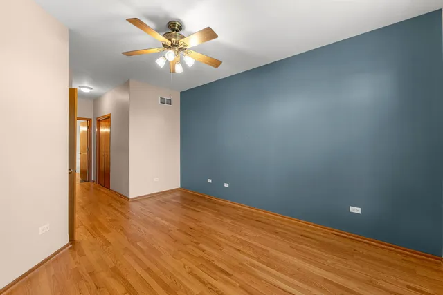 a view of an empty room with a chandelier fan