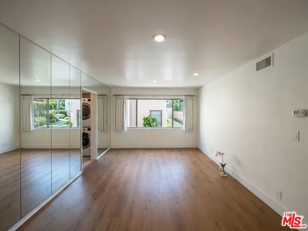 a view of empty room with wooden floor