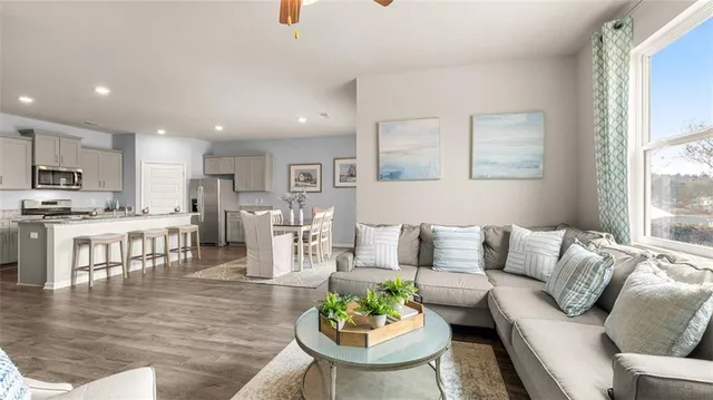 a living room with furniture kitchen and a table