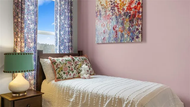 a bedroom with a bed and a painting on the wall