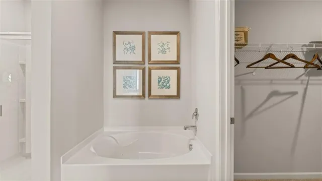 a white bath tub sitting next to a white cabinet
