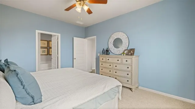 a bedroom with a bed and a lamp on dresser