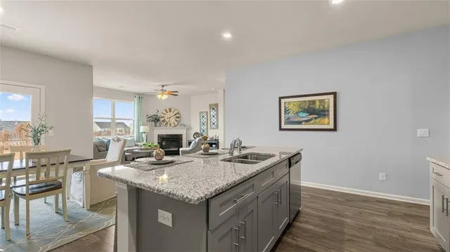 a living room with granite countertop furniture a fireplace and kitchen view