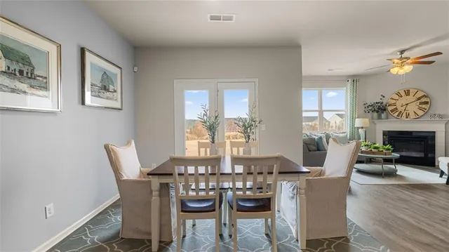a view of a dining room with furniture a chandelier and wooden floor